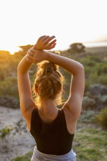 Teenage girl dancing at sunset