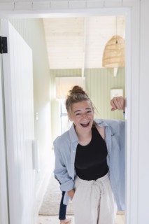Portrait of teenage girl standing in doorway and laughing