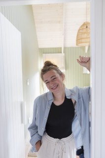 Portrait of teenage girl standing in doorway and smiling
