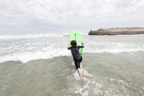 Boy bodyboarding on Voelklip beach