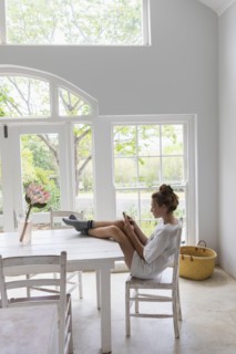 Teenage girl using smart phone in dining room