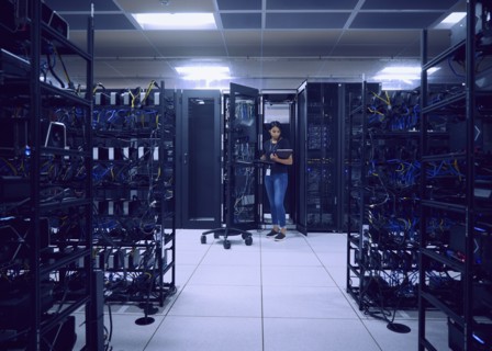 Female technician working in server room