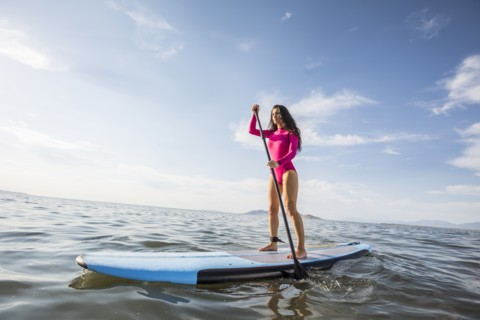 Woman standing on paddleboard in lake