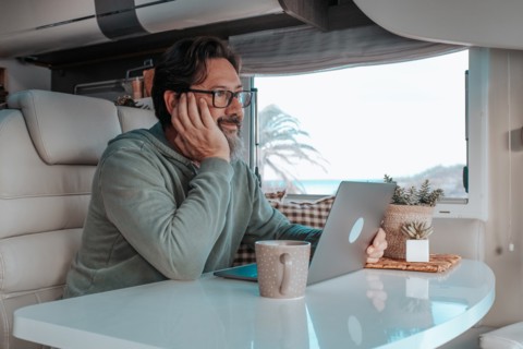 Man sitting in mobile home and working on laptop