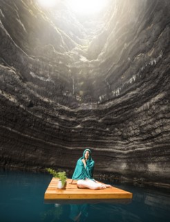 Portrait of woman sitting on floating dock near rocky coast