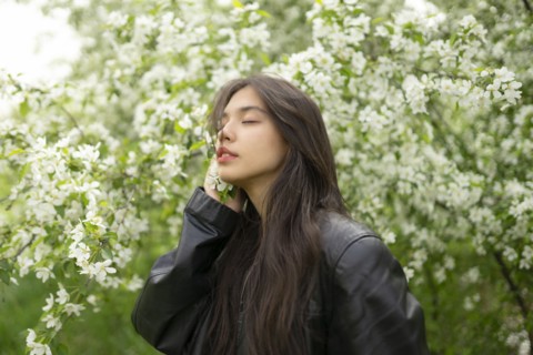 Portrait of teenage girl with blooming apple tree