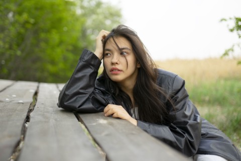 Portrait of teenage girl leaning on picnic table