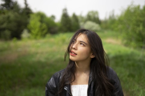 Portrait of teenage girl looking up in forest
