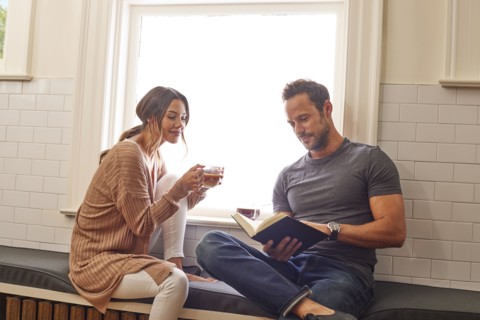 Smiling couple relaxing by window at home