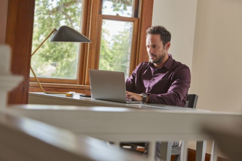 Man using laptop at table at home