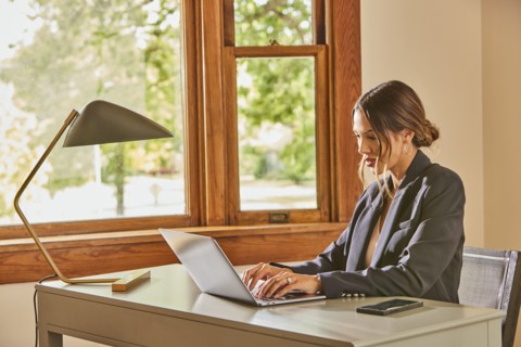 Woman using laptop and at desk at home