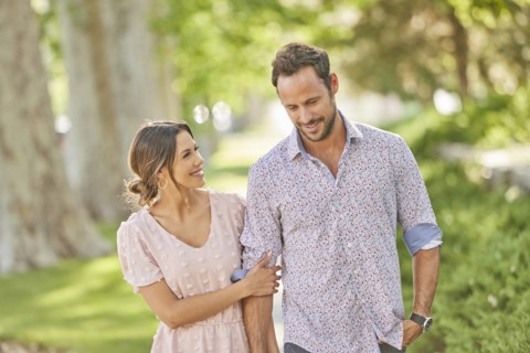 Smiling couple walking on treelined sidewalk