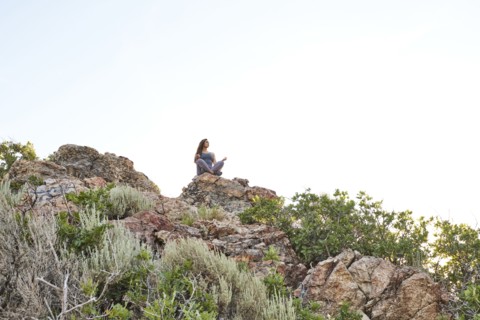 Mid adult woman meditating in mountains