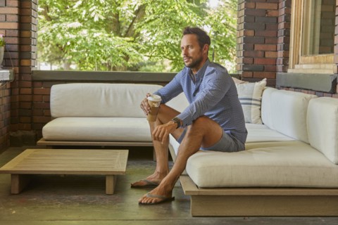Mid adult man relaxing on sofa on patio