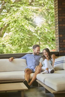 Mid adult couple relaxing on sofa on patio