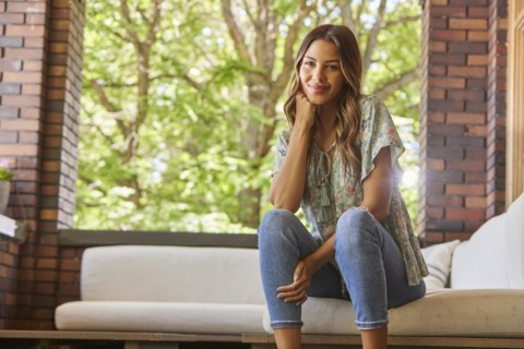 Portrait of mid adult woman relaxing on sofa on patio