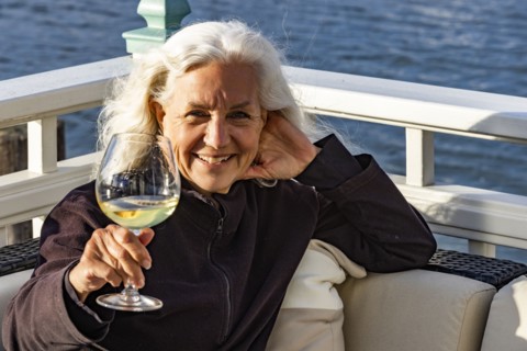 Portrait of smiling senior woman relaxing with glass of wine
