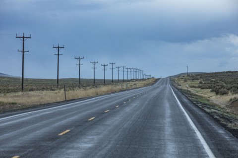 Electricity pylons along highway during stormy weather