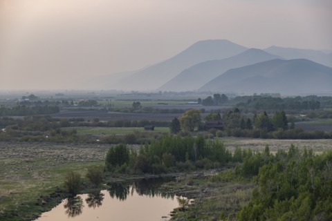 Landscape with small pond and mountains in background