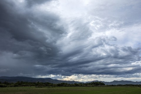 Storm clouds above landscape with meadow