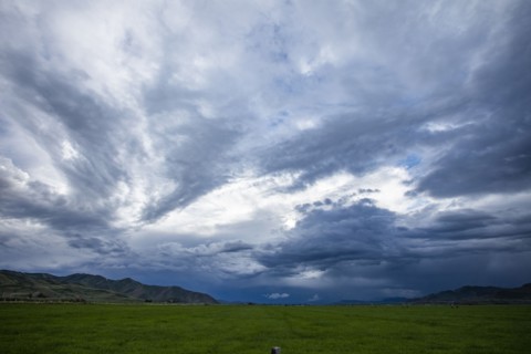 Storm clouds above landscape with meadow