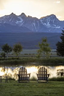 Scenic view of Sawtooth Mountains with pond at sunset