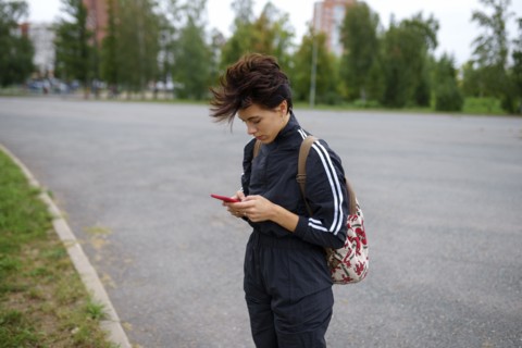 Young woman using smart phone in city street