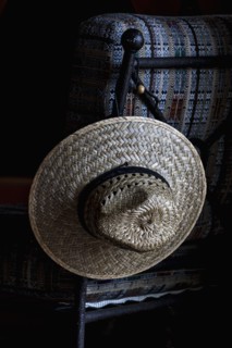Straw hat hanging on chair