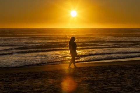 Silhouette of woman walking along Cannon Beach
