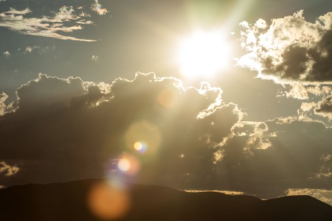 Lens flare from afternoon sun and clouds in sky