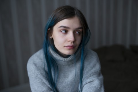 Portrait of serious woman in gray sweater