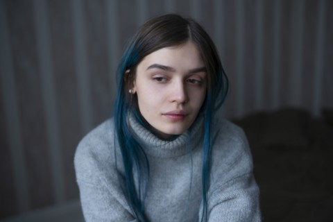 Portrait of serious woman in gray sweater
