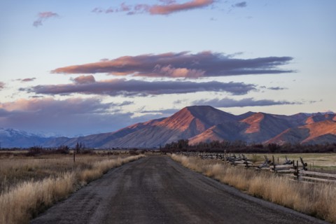 Empty dirt road leading to foothills at sunset, Bellevue, Idaho, USA