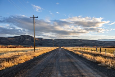 Empty dirt road crossing fields at sunset, Bellevue, Idaho, USA