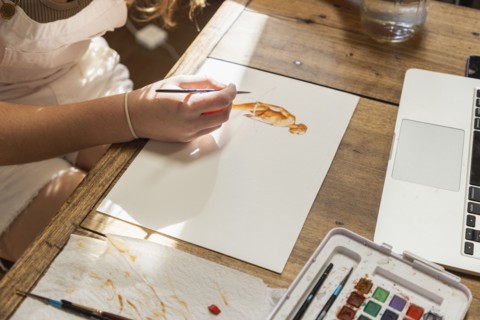 Close-up of teenage girl painting with watercolors at table, Lamy, New Mexico, USA