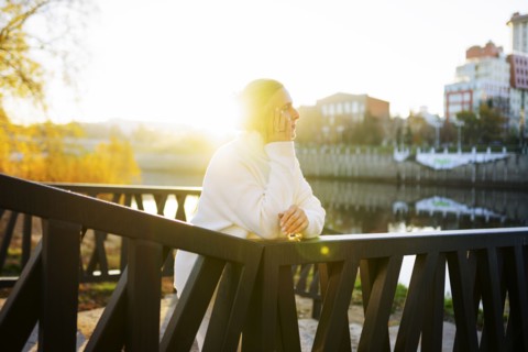 Woman in white sweater leaning on bridge, Omsk, , Russia