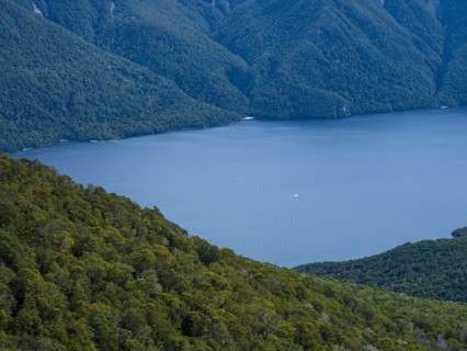 Blue lake surrounded with green hills, Te Anau, Fiordland, New Zealand