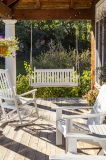 Rocking chair and swing on front porch of cottage house, Mt. Horeb, Wisconsin, USA