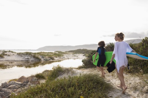 South Africa, Hermanus, Brother and sister walking on beach with body boards, Hermanus, , South