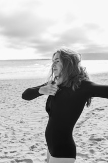 South Africa, Hermanus, Teenage girl putting on wetsuit on beach, Hermanus, , South Africa