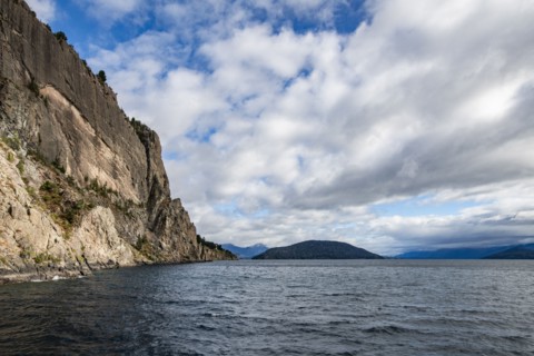Cumulus clouds over Lake Nahuel Huapi and cliff, Bariloche, Rio Negro, Argentina