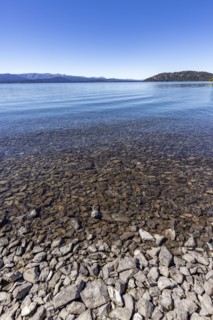 Rocky beach and calm lake on sunny day, Bariloche, , Argentina