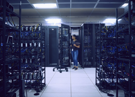 Female technician using computer in server room 
St, George, Utah, USA