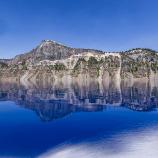 USA, Oregon, Cliffs reflected in calm surface of Crater lake