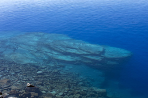 USA, Oregon, Rocks in blue calm Crater Lake