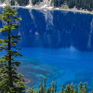 USA, Oregon, Cliffs reflected in calm surface of Crater lake