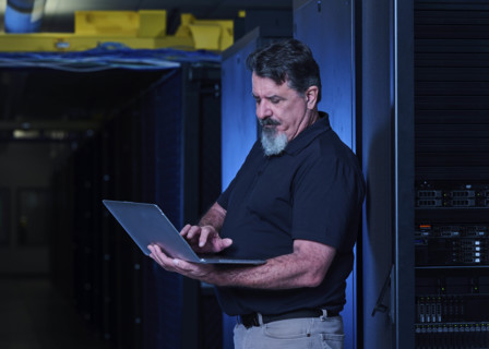 Man using laptop in data center