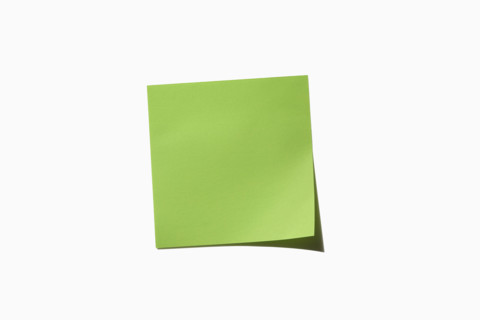 Green post it note on white background