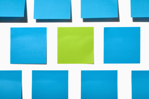 Blue and green post it notes on white background