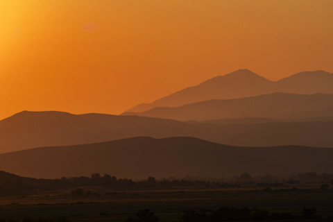 USA, Idaho, Bellevue, Silhouettes of hills against orange sky at sunset